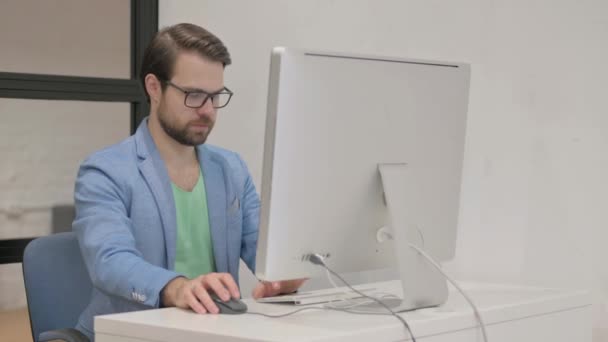 Возбужденный Молодой Человек Празднует Успех Настольном Компьютере Офисе — стоковое видео