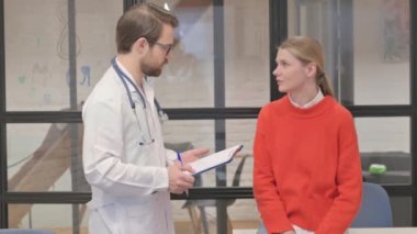 Klinikte erkek doktor hastasıyla konuşuyor.