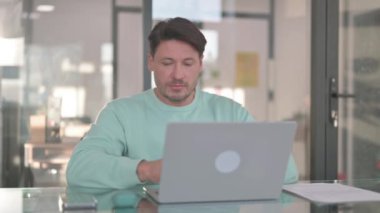 Dizüstü bilgisayarda çalışan orta yaşlı adam