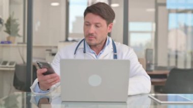 Olgun Yetişkin Doktor Akıllı Telefon ve Laptop Kullanıyor