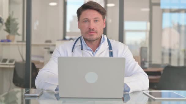 Doctor Mirando Cámara Mientras Trabaja Ordenador Portátil — Vídeos de Stock