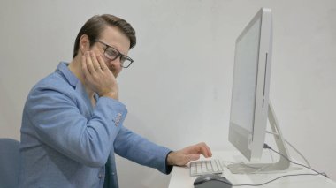 Diş ağrısı olan kıdemli iş adamı Masaüstünde çalışıyor