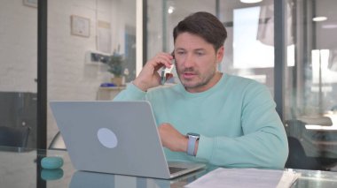 Casual Man Talking on Phone, Discussing Work