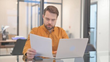 zakenman werken aan documenten en laptop