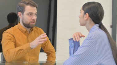 Ofiste kendinden emin genç iş adamları konuşuyor.