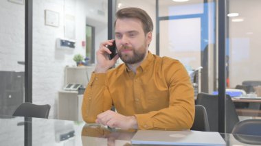 Sıradan yaratıcı adam telefonda konuşuyor.