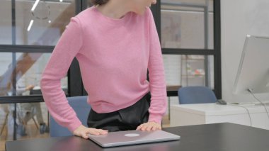 Laptop 'ta çalıştıktan sonra ofisten ayrılan genç kadın.