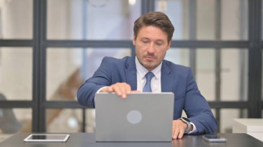 Orta Çağ İşadamı Dizüstü bilgisayarla çalıştıktan sonra ofisten ayrılıyor