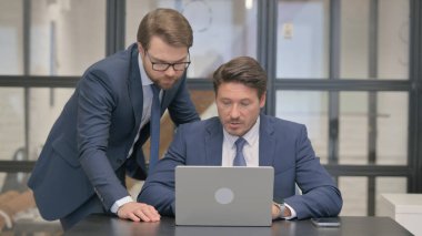 Dimdik İşadamı Dizüstü bilgisayar üzerinde çalışırken takım arkadaşına yardım ediyor