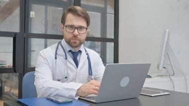 Ciddi Olgun Yetişkin Doktor Hastanedeki Kameraya Bakıyor