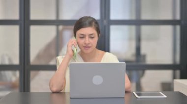 İş yerinde konuşan genç Hintli kadın.