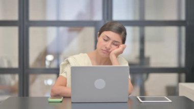 Dizüstü bilgisayarın önünde uyuyan yorgun Hintli kadın.