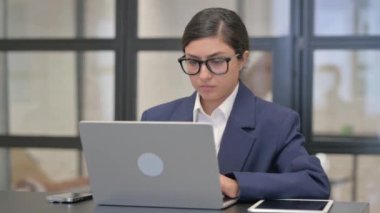 Şaşırmış Karışık Irk İş Kadını Bilgisayarda çalışırken Kameraya Bakıyor