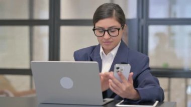 Karışık Yarış İşkadını Akıllı Telefon Tutuyor ve Dizüstü bilgisayar Kullanıyor