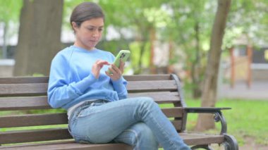 Açık havada oturan Hintli Kadın Telefondaki Kayıp 'tan Üzgündü