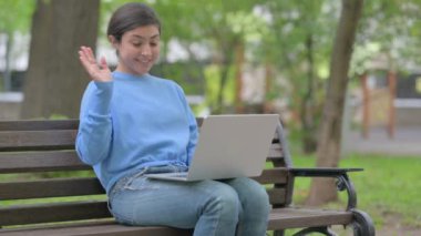 Açık havada oturan Hintli Kadın Laptop 'ta Video Sohbeti İçin Konuşuyor