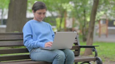 Açık havada oturan Hintli kadın dizüstü bilgisayarında kaybından şok oldu.