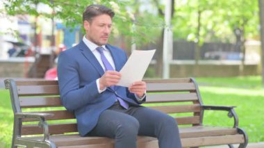 Bankta otururken İşadamı Belgeleri Okurken