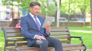 Tablet 'te Video Sohbeti Yapan İşadamı Bench' te otururken