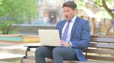 İşadamı Bench 'te otururken Laptop' ta Kaybından Şok Oldu