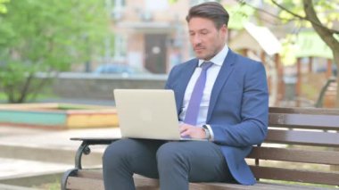 Bankta Dizüstü bilgisayar kullanırken Kameraya Bakan İşadamı