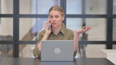Kızgın İşadamı Laptop 'ta çalışırken telefonda konuşuyor