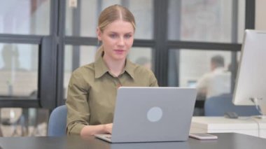 Dizüstü bilgisayar kullanan Genç İş Kadınından Başparmak Düşürme