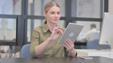 Ofiste dijital tablet kullanan genç iş kadını