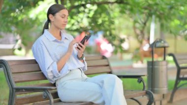 Açık havada otururken telefonda Kayıp Yarış Kadını Üzüntüsü