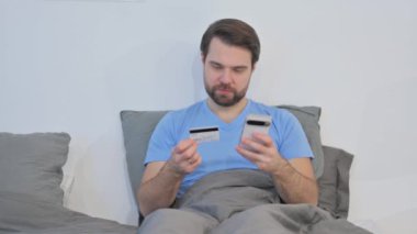 Orta Yaşlı Adam İnternetten Yatakta Alışveriş Yapıyor