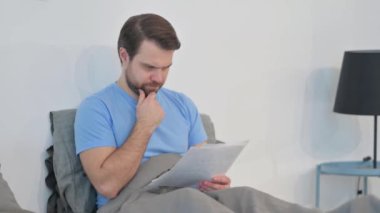 Yatakta Belgeleri Okuyan Orta Yaşlı Adam