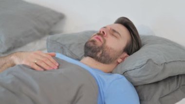 Huzursuz Orta yaşlı adam yatakta uyurken kabus görüyor.