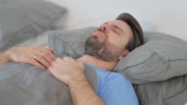 Orta yaşlı bir adam uykusundan uyanır.