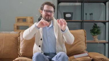 Mutlu adam evde otururken dans ediyor.