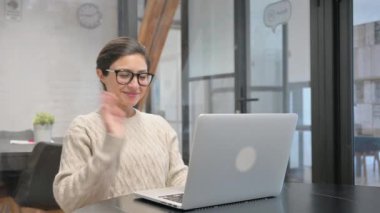 Ofiste dizüstü bilgisayarla görüntülü konuşma yapan Hintli kadın.