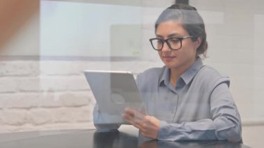İşyerindeki Dijital Tablet üzerinde çalışan Hintli İş kadını