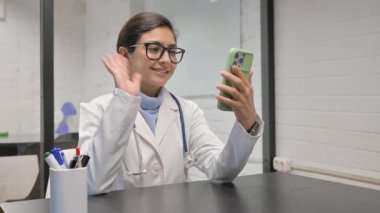 Klinikte Hintli genç doktorun online görüntülü sohbeti.