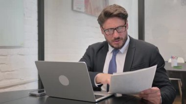 Belgeler ve Dizüstü bilgisayar üzerinde çalışan Orta Çağ İşadamı