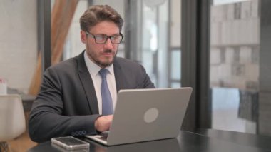 Dizüstü bilgisayarında Sırt Ağrısı Yazan Olgun Yetişkin İş Adamı