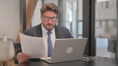 Olgun Yetişkin İş Adamı Belgeler ve Laptop Üzerinde Çalışıyor