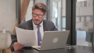 Dizüstü bilgisayar ve Belgelerde Kutlama yapan İşadamı