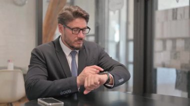 Yetişkin İş Adamı Çalışma Alanında Akıllı Saat Kullanıyor