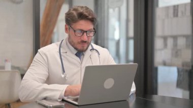 Young Doctor Smiling at Camera in Clinic