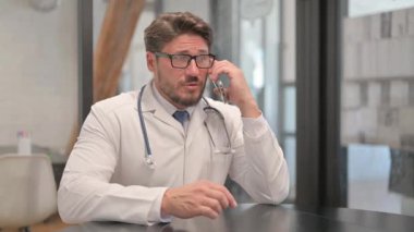 Young Doctor Talking on Phone in Clinic