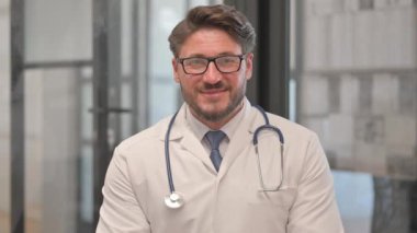 Kameraya bakan gülümseyen orta yaşlı doktorun portresi
