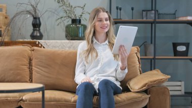 Tablet 'te Video Sohbeti Yapan Genç Kadın Evdeki Koltukta Otururken