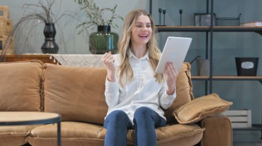 Tabletteki Başarıyı Kutlayan Genç Kadın Evdeki Koltukta Otururken