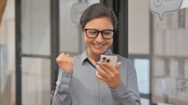 Çevrimiçi Başarı İçin Genç Hintli İş kadınının telefonuyla Tepki