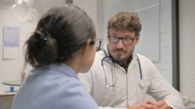 Klinikteki Hastayla Orta yaşlı Doktor Konuşuyor