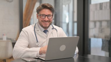 Young Doctor Smiling at Camera in Clinic